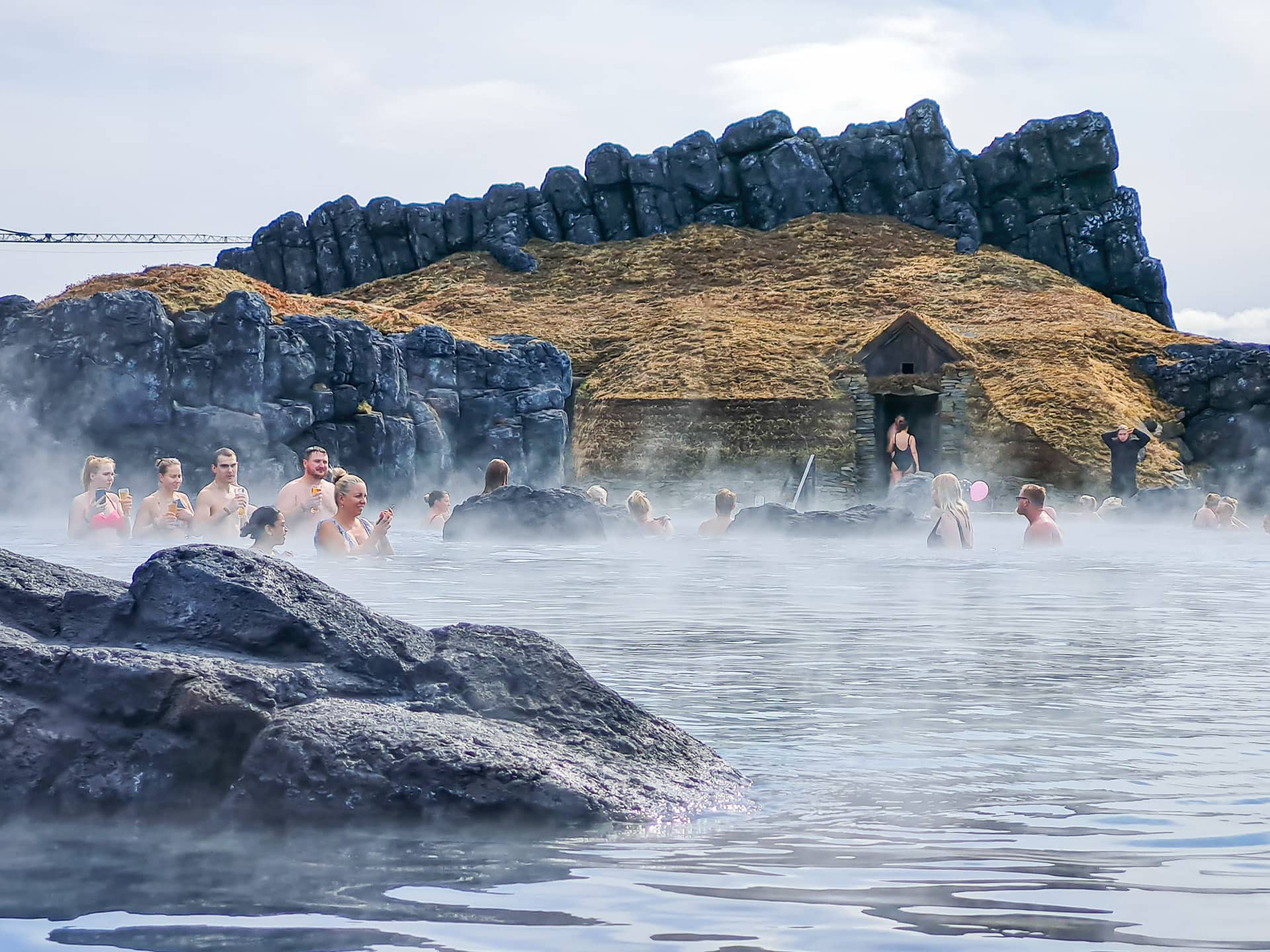 Sky Lagoon Geotermikus medence lávafalakkal és gőzzel körülvéve