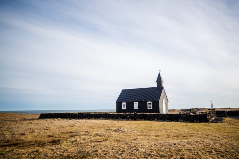„Búðakirkja fekete templom hófödte tájban, háttérben a Snæfellsnes-félsziget hegyei – téli látkép Izlandon.”