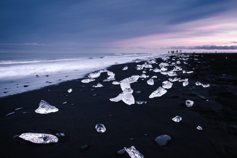 Izland Diamond Beach, jégdarabok a fekete homokon naplementében