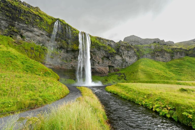 A Seljalandsfoss-vízesés és a mögötte futó sétaút Izland déli részén.