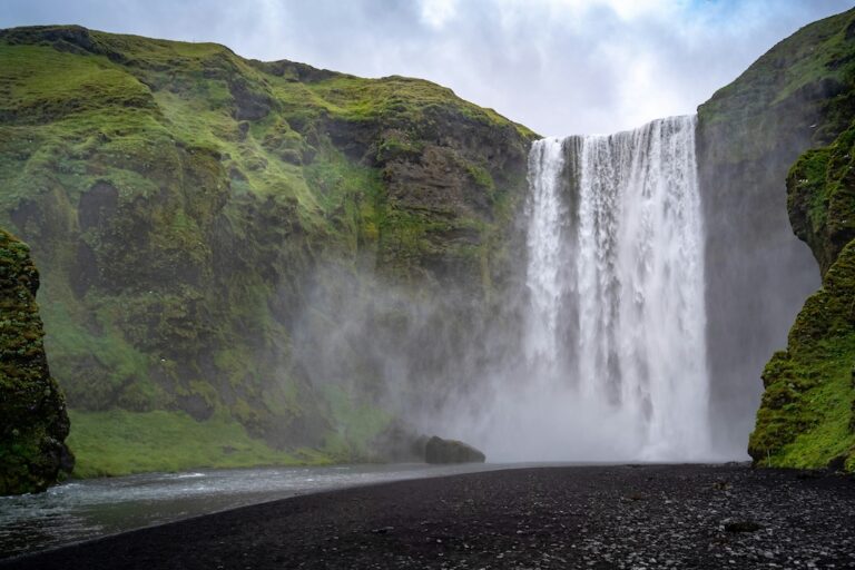 Skógafoss vízesés vízpárája és zöld mohával borított sziklái Izland déli részén.
